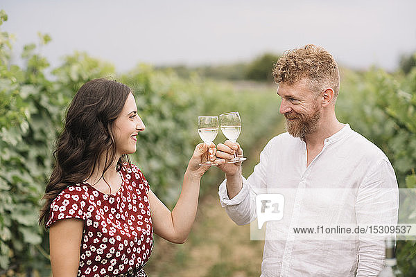 Couple toasting with white wine in the vineyards