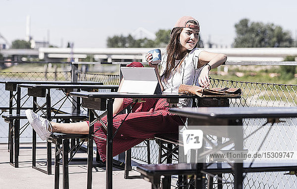 Young woman relaxing in a beer garden looking around
