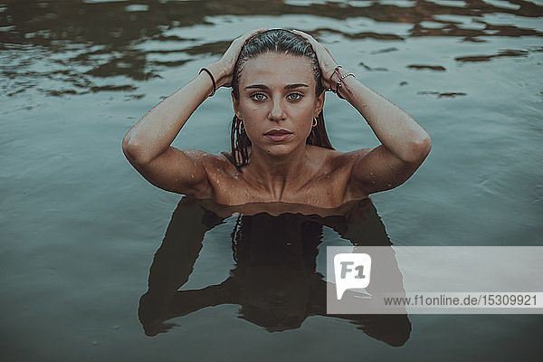 Porträt einer jungen blonden Frau  die in einem See badet
