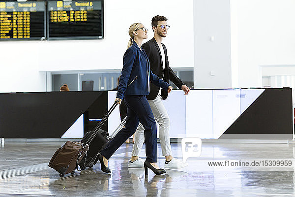 Two young business partners walking at the airport