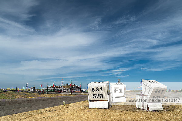 Deutschland Schleswig-Holstein Sankt Peter-Ording Kapuzenstrandkörbe und das Fischrestaurant Gosch im Hintergrund