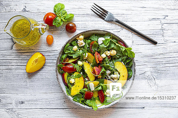 Direkt über Ansicht von frischem Salat in Schüssel von Krug und Gabel auf dem Tisch