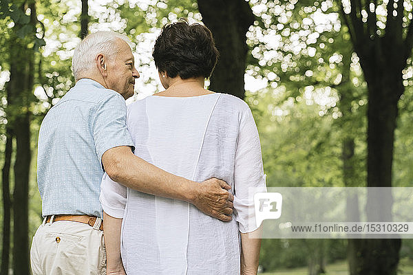 Rückenansicht eines älteren Paares beim Spaziergang in einem Park