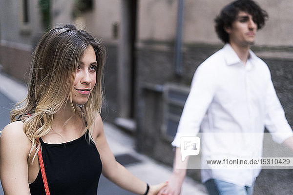 Young couple walking hand in hand in the city