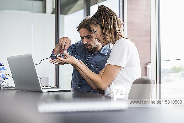 Junge Frau und Mann arbeiten an Computerausrüstung im Büro