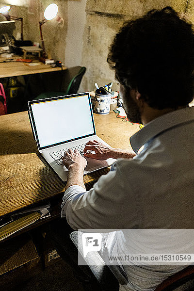 Businessman using laptop on table in the dark