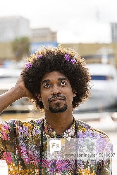 Bildnis eines Mannes mit Blüten im Haar und farbigem Hemd