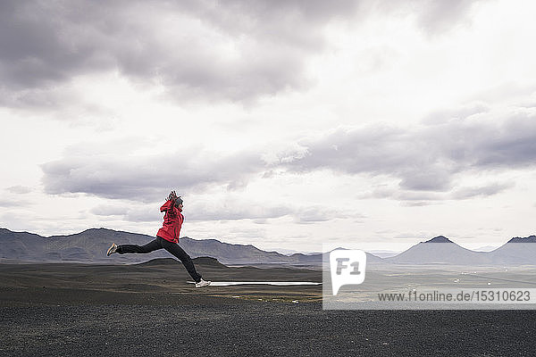 Reifer Mann springt vor Freude in der Hochlandregion  Island