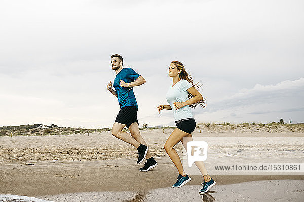 Young couple jogging on the beach