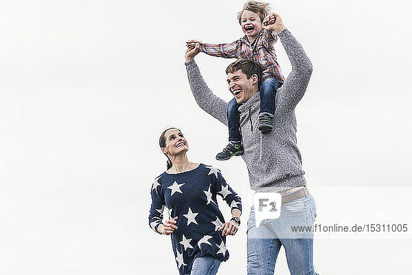 Glückliche Familie geht gemeinsam spazieren  Vater trägt Sohn huckepack