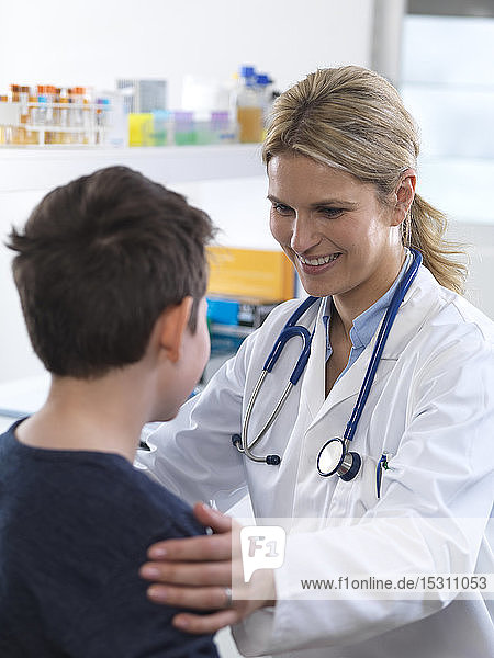 Ärztin gibt einem Jungen bei einem Termin in der Klinik eine Anleitung