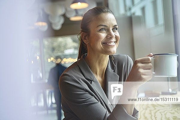 Lächelnde Geschäftsfrau in einem Café beim Kaffeetrinken