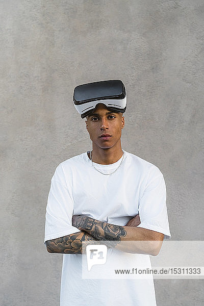 Porträt eines tätowierten jungen Mannes mitVirtual-Reality-Brille