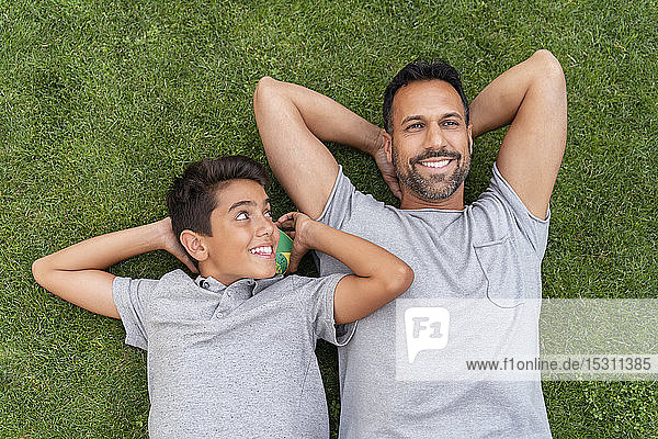 Glücklicher Vater und Sohn liegen zusammen im Gras