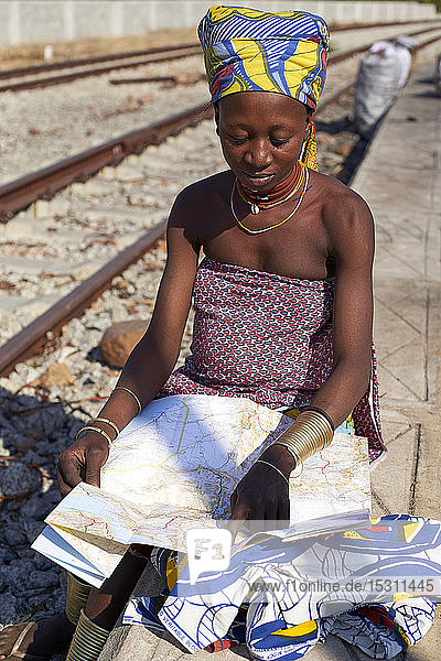 Ndengelengo woman checking a map at the train station  Garganta  Angola.