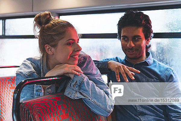 Junges Paar reist an einem regnerischen Tag mit dem Bus  London  Großbritannien