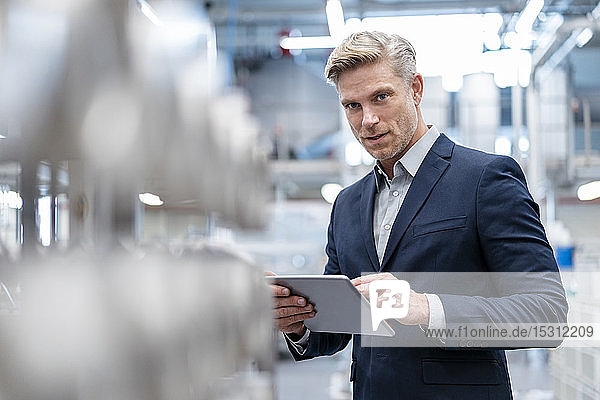 Portrait of businessman with tablet in a modern factory