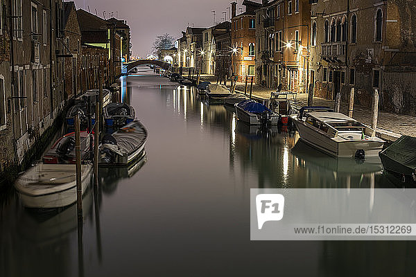 Boote  die nachts in Venedig inmitten von Gebäuden im Kanal anlegen