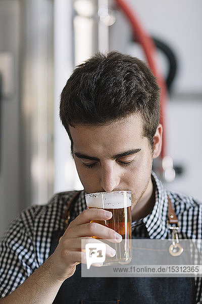 Junger Mann testet Bier in einer Brauerei