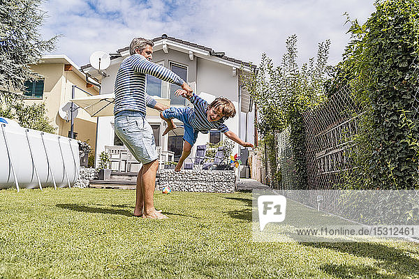Vater spielt mit Sohn im Garten