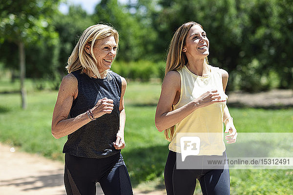 Mature woman running with her daughter in a park