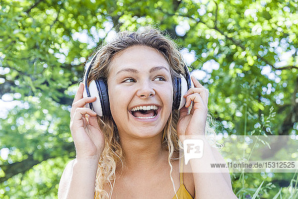 Lächelnde Frau  die Musik hört und zur Seite schaut