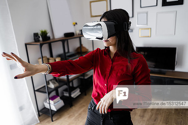 Junge Frau mit VR-Brille zu Hause