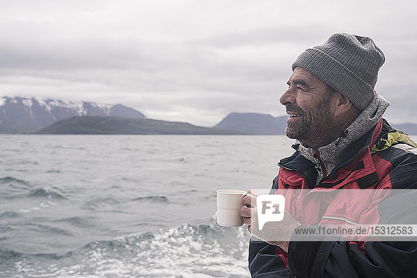 Mature man looking at the sea  boating on Eyjafjordur Fjord  Iceland