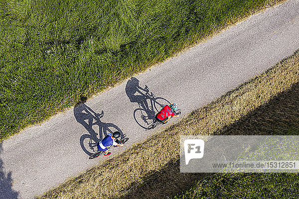 Triathletes riding bicycle on country road  Germany