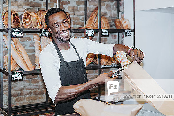 Lächelnder Mann bei der Arbeit in einer Bäckerei