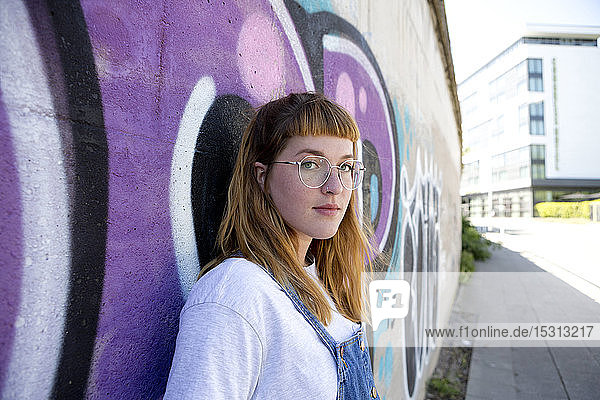 Young woman in front of purple graffiti