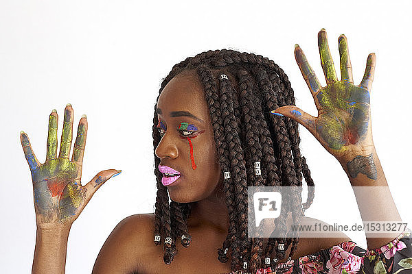 Portrait of woman with painted face against white background