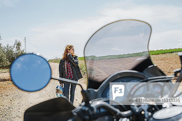 Woman with motorbike in field landscape