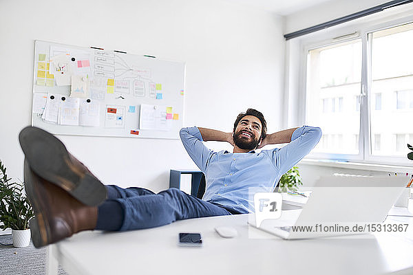 Smiling businessman relaxing at a desk