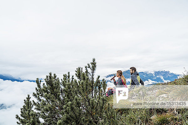 Junges Paar auf einer Wanderung in den Bergen bei einer Pause  Herzogstand  Bayern  Deutschland