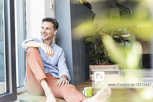Mature man relaxing at home with a cup of coffee