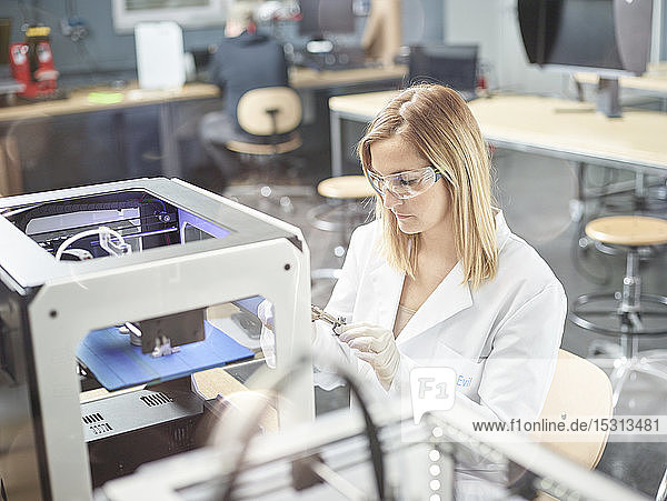 Weibliche Technikerin prüft 3D-Drucker