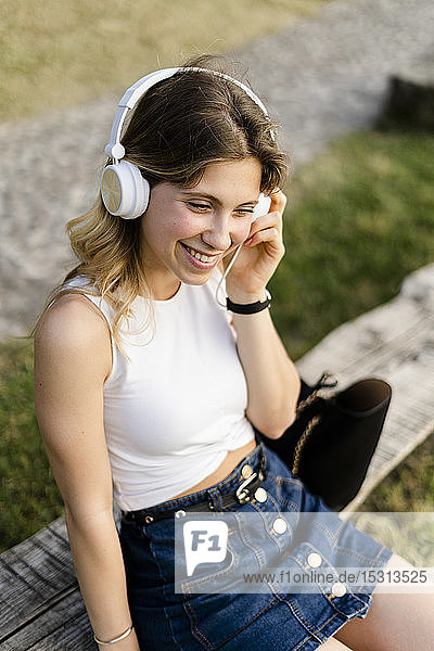 Portrait of happy young woman listening music with headphones