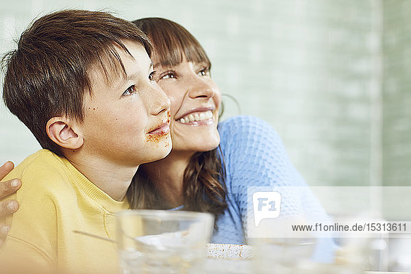 Happy mother sitting in kitchen with her son