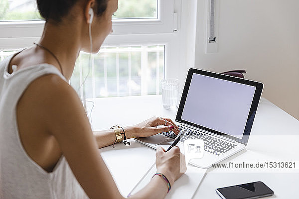 Junge Frau lernt mit ihrem Laptop zu Hause