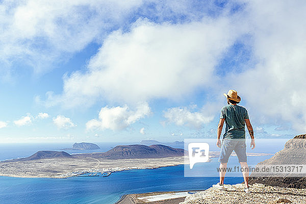 Mann auf Aussichtspunkt mit Blick auf die Insel La Gracioas von Lanzarote  Kanarische Inseln  Spanien