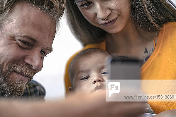 Family with baby using cell phone