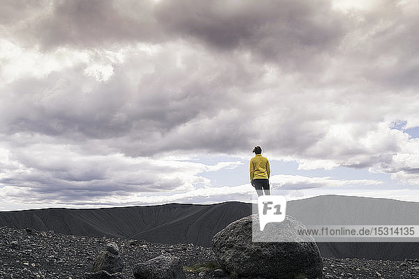 Junge Frau steht auf dem Krater Hverfjall in der Nähe von Myvatn  Island  und fotografiert