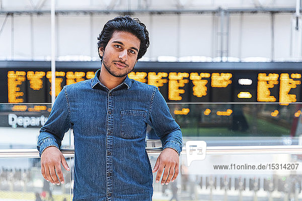 Porträt eines Mannes in Jeanshemd am Bahnhof  London  UK