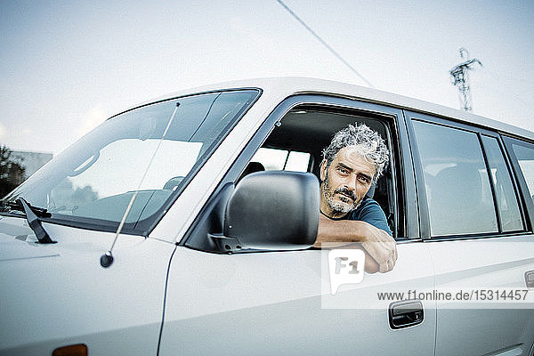 Mature man sitting in his off-road vehicle