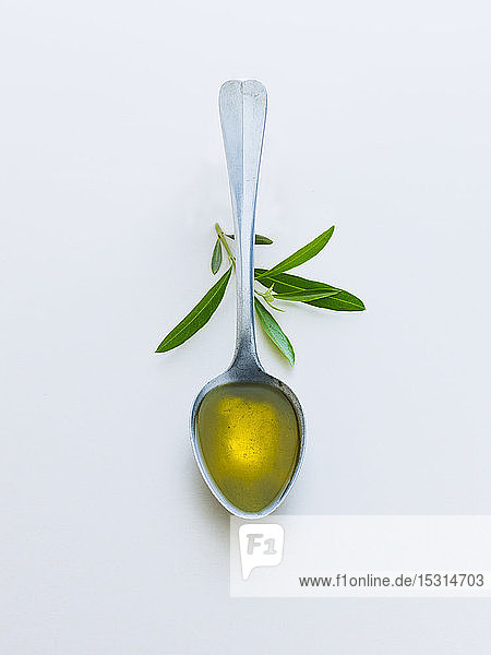 Löffel mit Olivenöl mit Olivenblättern
