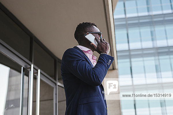 Young businessman using his smartphone outside