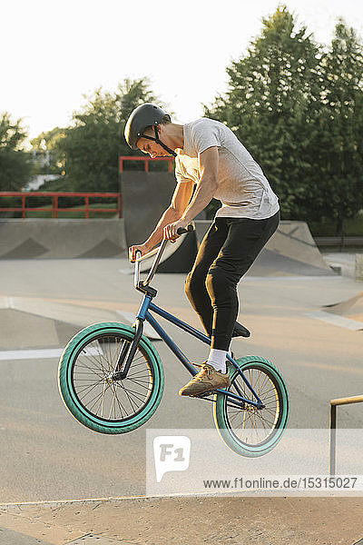 Young man riding BMX bike at skatepark
