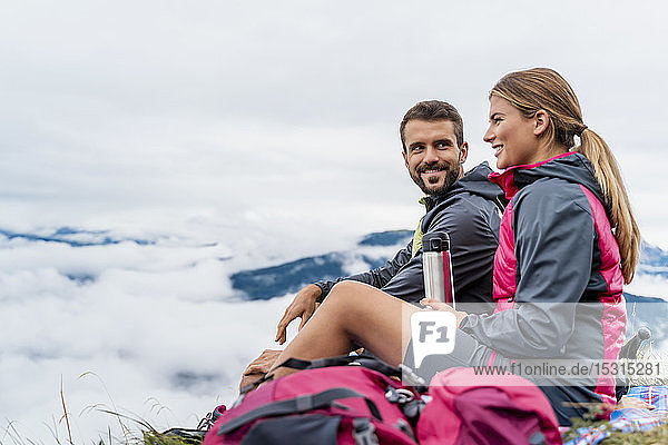 Young couple on a hiking trip in the mountains having a break  Herzogstand  Bavaria  Germany