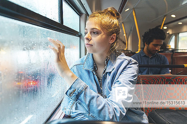 Junge Frau im Bus schreibt mit dem Finger auf beschlagener Fensterscheibe  London  UK